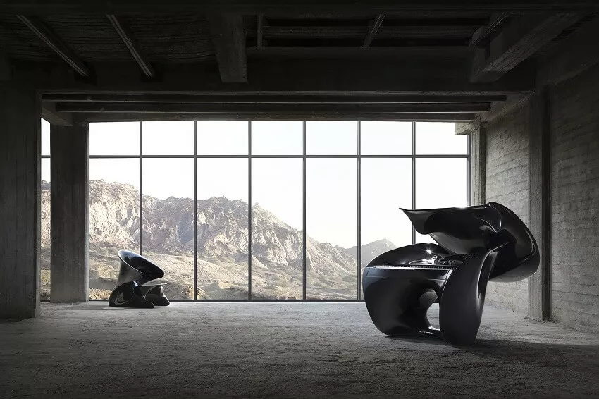 Sculptural concrete interior with a large window and black lounge chair